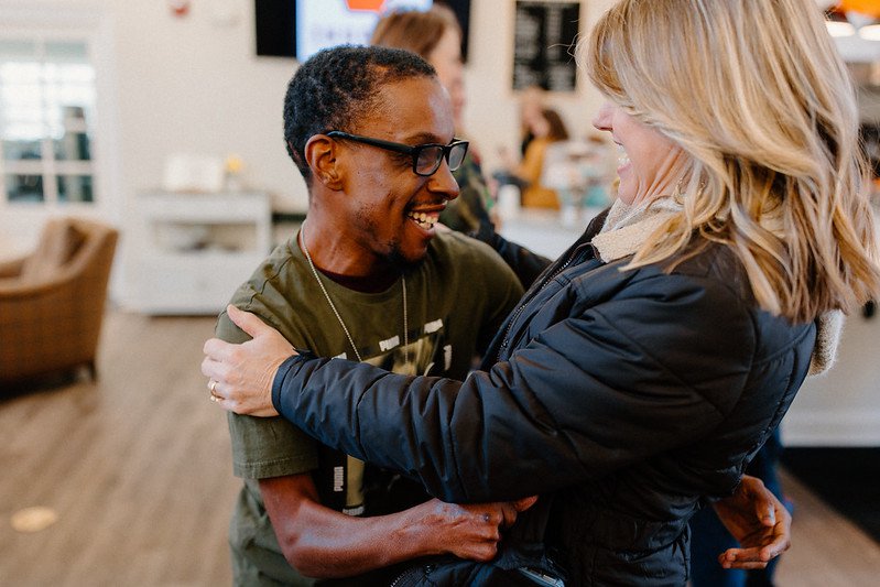 Man with special needs smiles and hugs woman