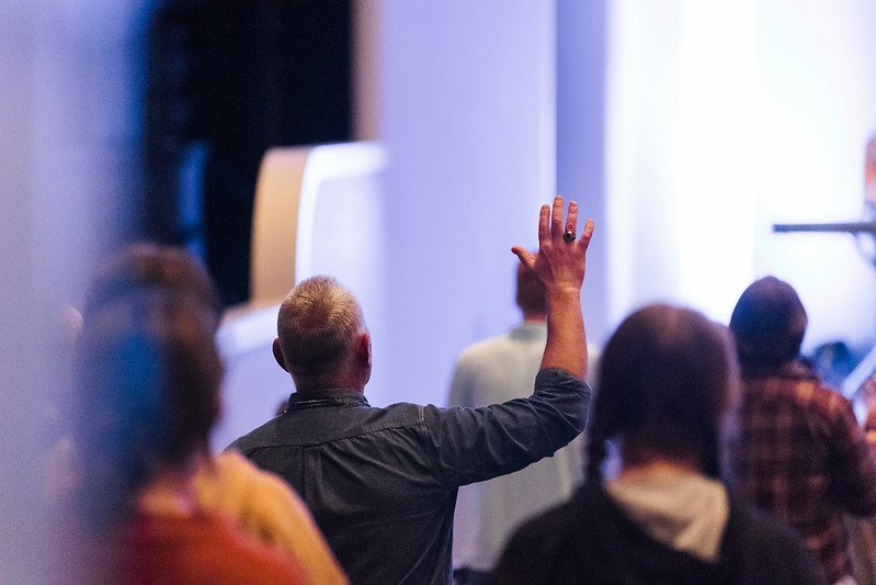 Man worshipping with his hand up