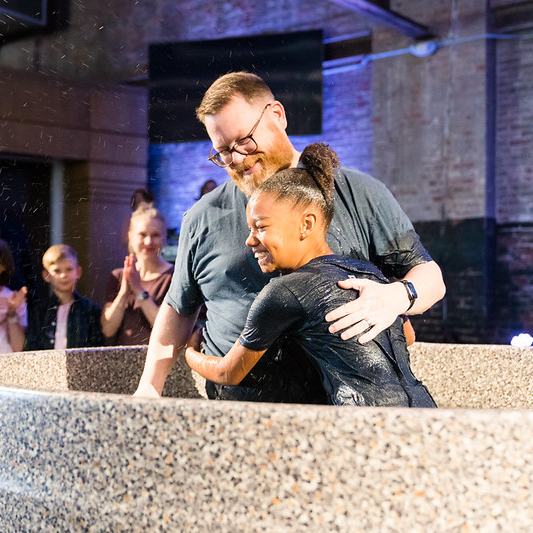 Pastor baptizes girl as onlookers celebrate