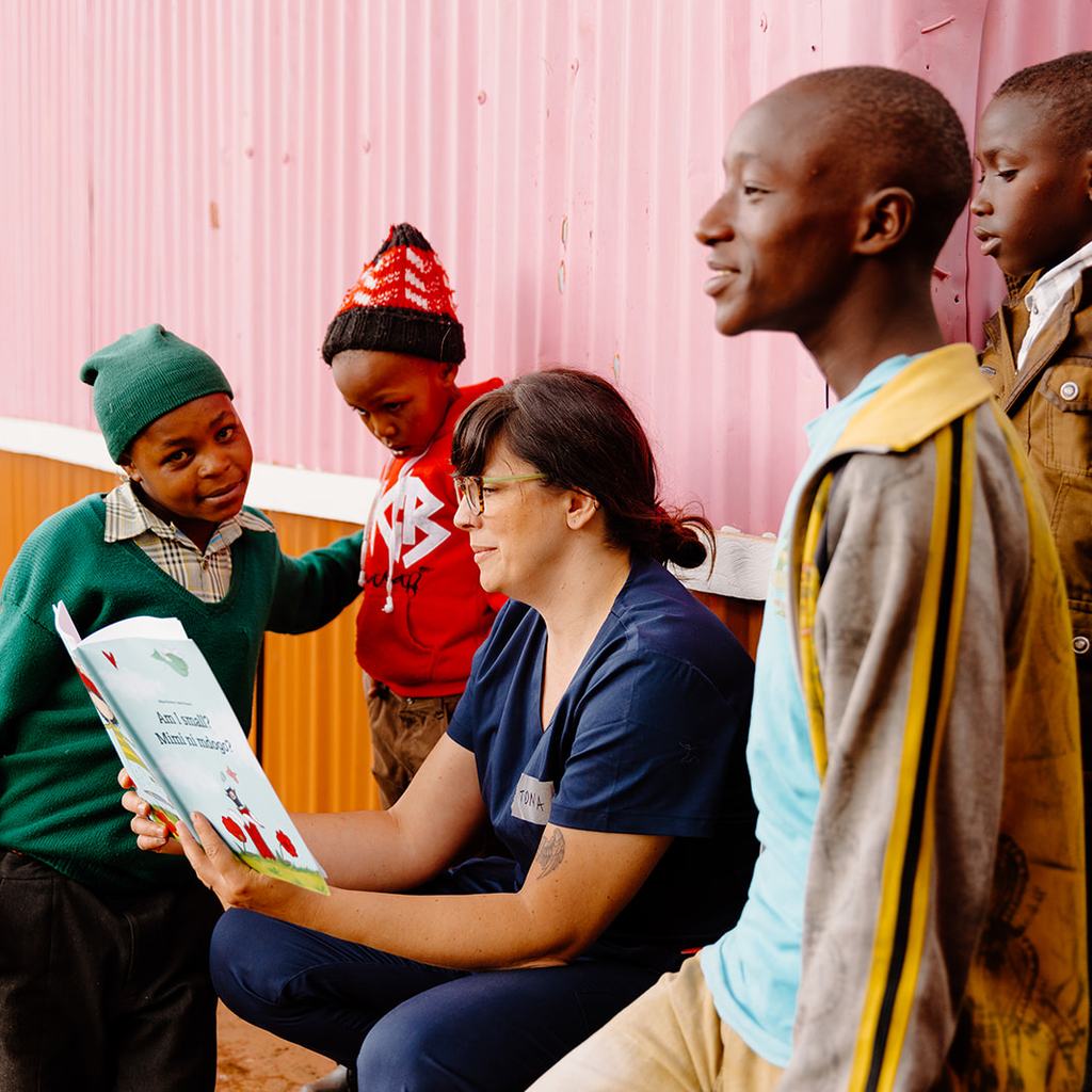 Kenya Mission Trip Volunteer Reading to Children April 2023