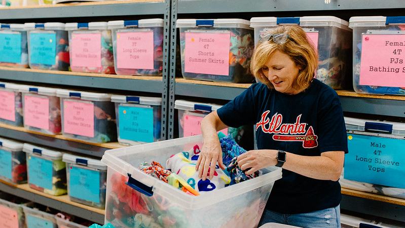 Woman Sorting through Bin in Foster and Adopt Resource Center