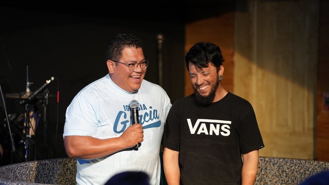 Man smiling with pastor during his baptism