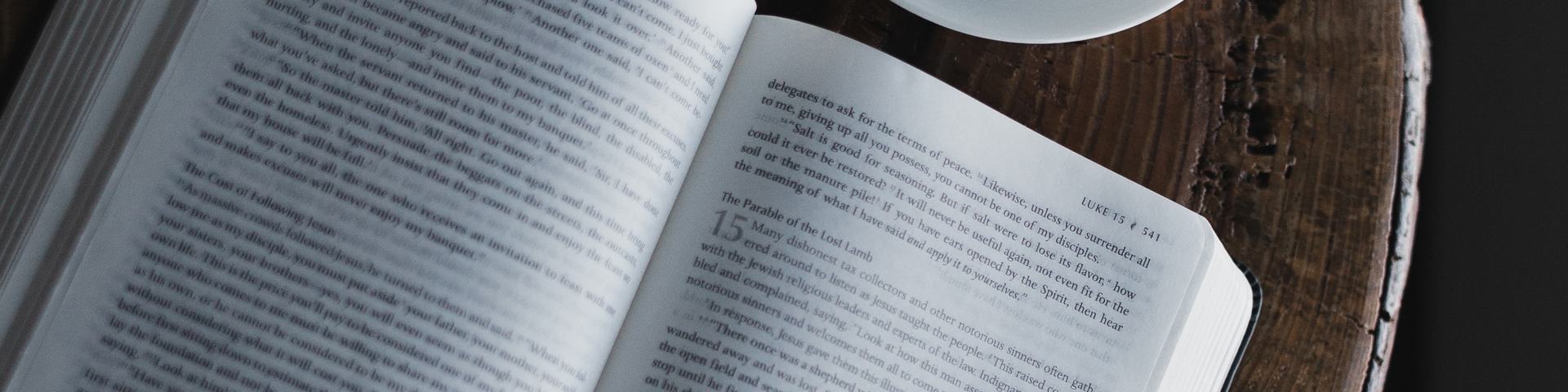 Open Bible on table with latte