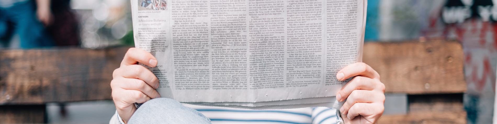 Person Holding up Newspaper