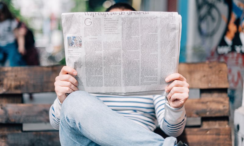 Person Holding up Newspaper