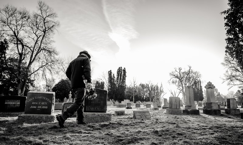 Man Taking Flowers to Grave